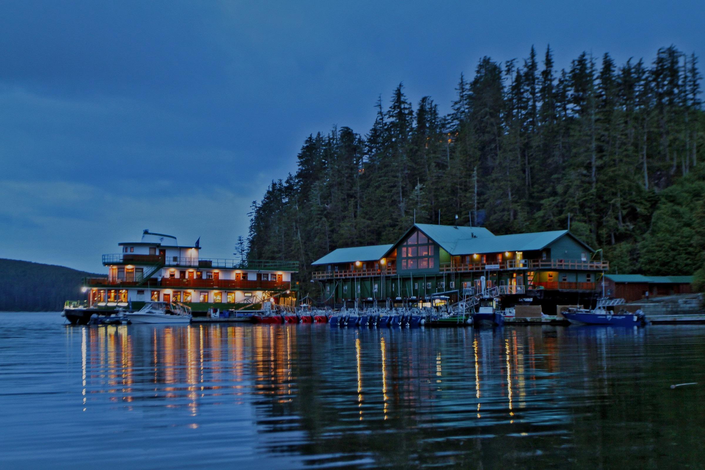 Langara Fishing Lodge illuminated beside the water at dusk